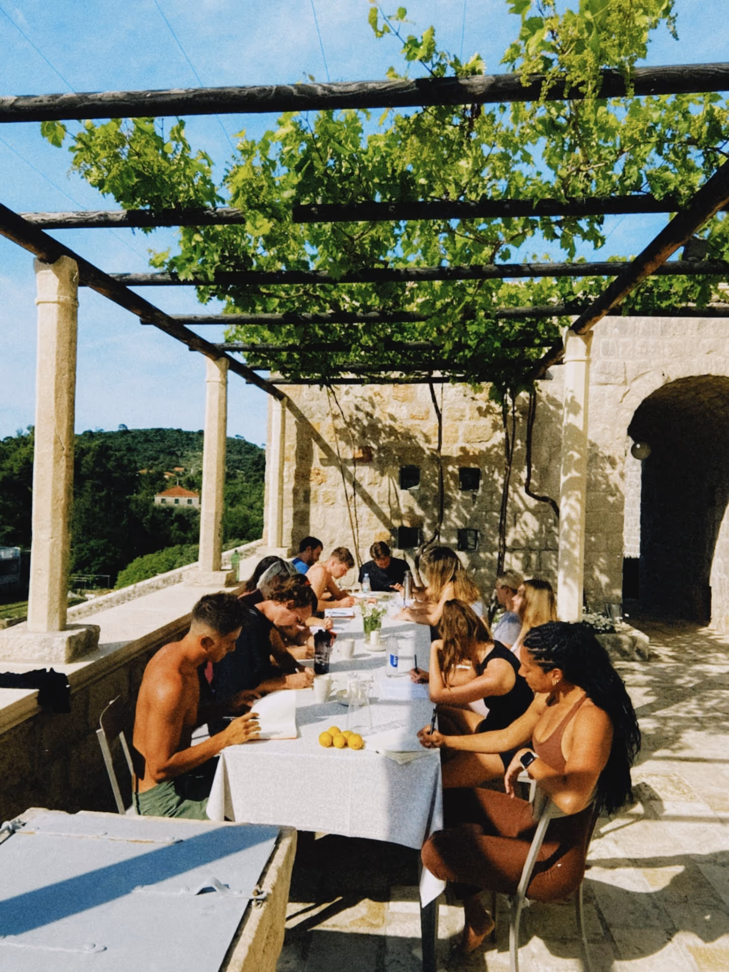 Members journaling under a pergola in Croatia